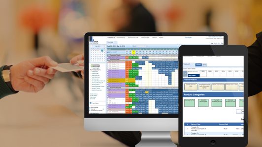 a computer and tablet showing a spreadsheet