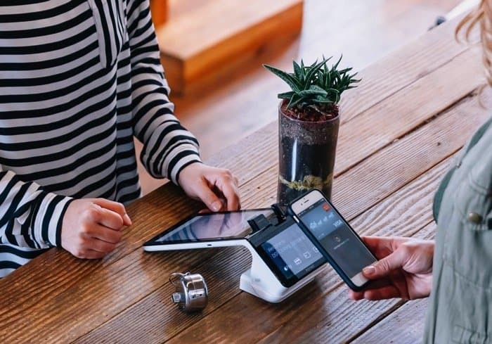 a person using a device to pay for a phone