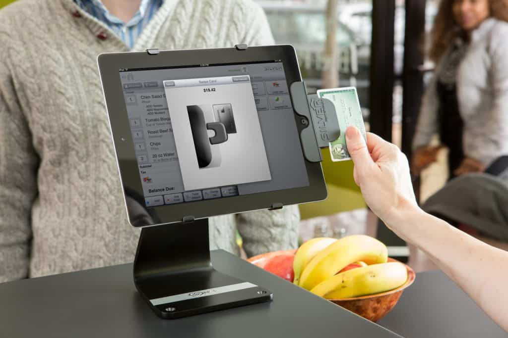 a person holding a credit card and a tablet